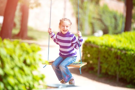 happy smiling little girl on swing