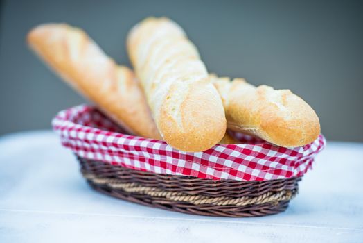 delicious fresh baguette in a basket on table