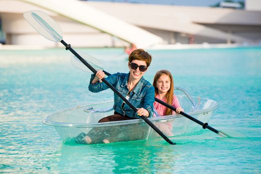 Little girl with her mother in a transparent kayak ride