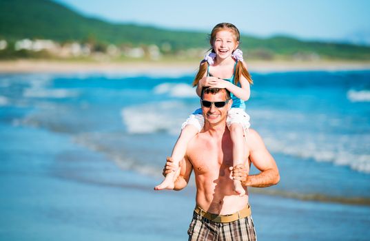 Happy father and his adorable little daughter on the beach