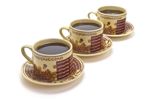 Three ceramic cups of coffee on white background