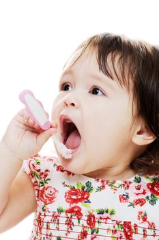 Little girl brushing teeth with pink toothbrush