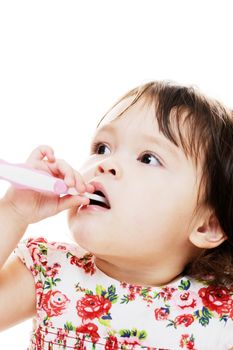 Young girl cleaning her teeth with pink toothbrush