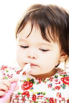 Little girl with pink toothbrush cleans her teeth