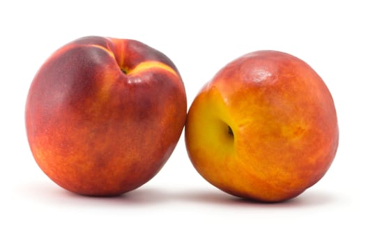 two juicy ripe nectarine on a white background