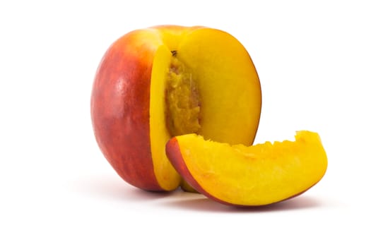 one ripe juicy nectarine and cut portion on a white background