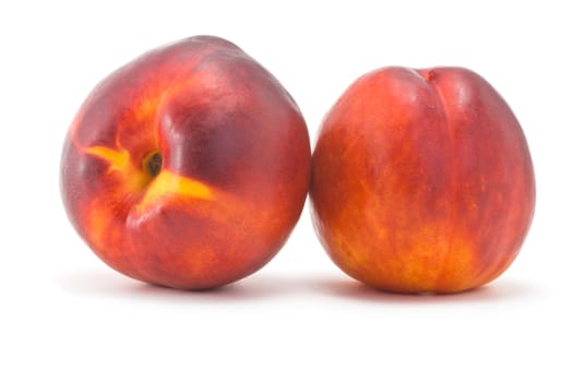 two juicy ripe nectarine on a white background