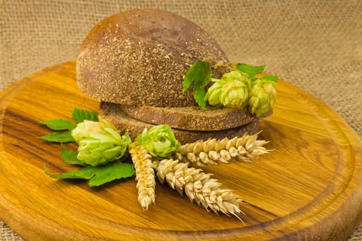 sliced ??bread, hop cones, spikes on the board and on the background of coarse cloth