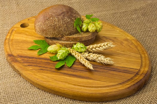 sliced ??bread, hop cones, spikes on the board and on the background of coarse cloth