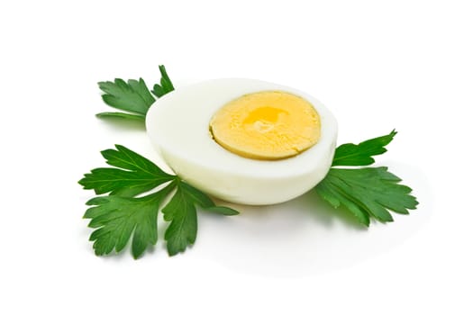 half of boiled egg with parsley leaves on a white background