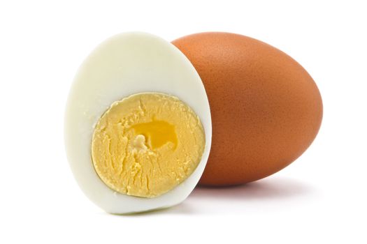 one egg and half a boiled egg on a white background