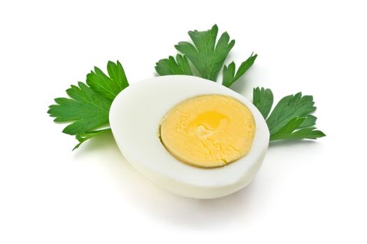 one half of boiled egg with parsley leaves on a white background