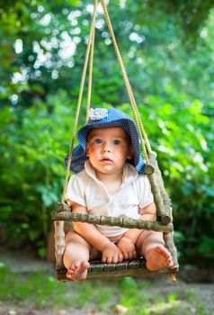 Little baby girl playing in a summer garden