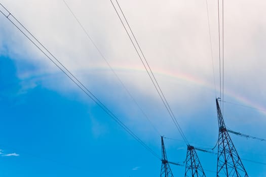 power line pylon, cable background with rainbow, sky, clouds