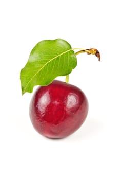 single ripe, juicy, delicious sweet cherry and green leave isolated on white background