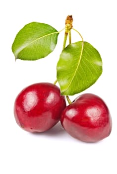 Two ripe, juicy, delicious sweet cherry and green leaves isolated on white background