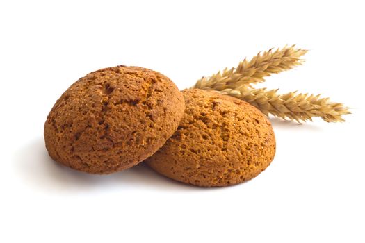 Oatmeal cookies and spikelets on white background