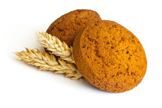 Oatmeal cookies and spikelets on white background