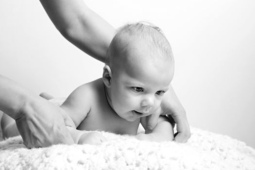 A cute newborn baby boy on a blanket laying on his belly in black and white.