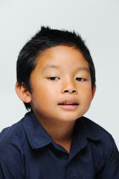 Asian boy looking down with blue shirt