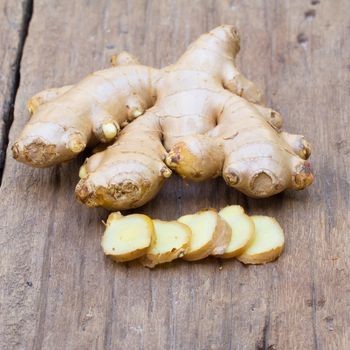 Fresh Ginger root on wooden and ginger slice on wood background