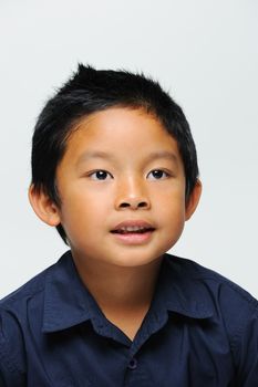 Asian boy smiling at camera wears blue shirt