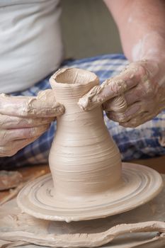 Hands of a potter, creating an earthen jar on the circle