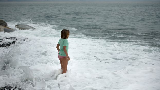 little girl on the seashore thinking about the summer is coming
