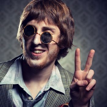 Funny 1960s style guy after snorting cocaine on vintage wallpaper background.