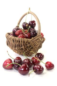 fresh red juicy cherries in a basket on light background