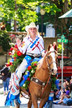 Portland, Oregon, USA - JUNE 7, 2014: Miss Vancouver Rodeo Queen, Amanda Knapp in Grand floral parade through Portland downtown.