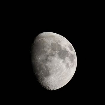 Waxing gibbous moon over dark sky at night