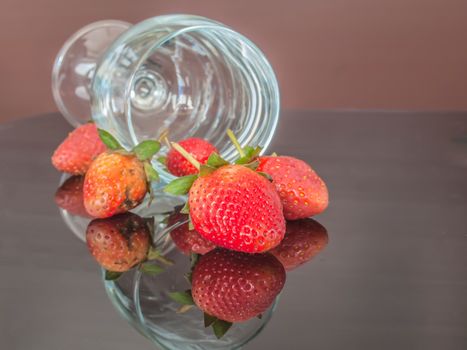 strawberries and glass wine on brown background