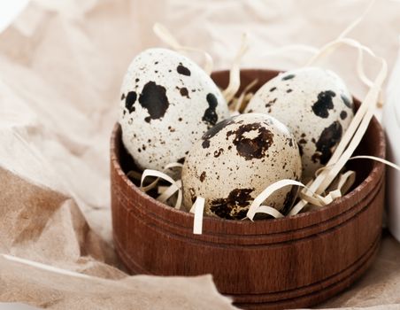 Quail eggs in wooden box on craft paper