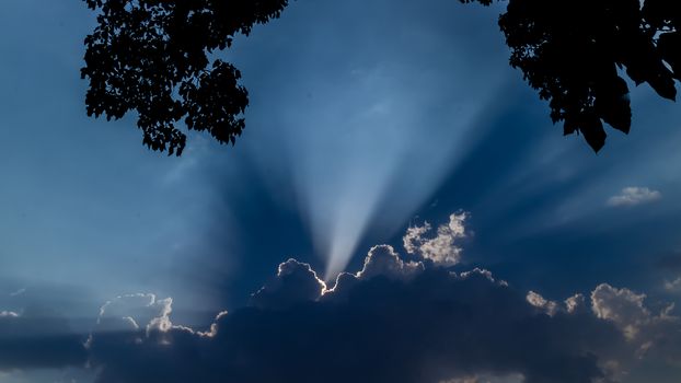 The sun shinning behind the clouds on a late afternoon right after a rainfall