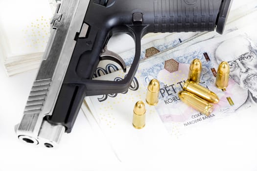 detail of gun with bullet on czech banknotes background