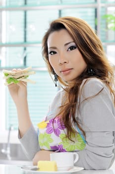 Happy asian woman cooking in the kitchen