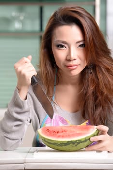 Happy asian woman cooking in the kitchen