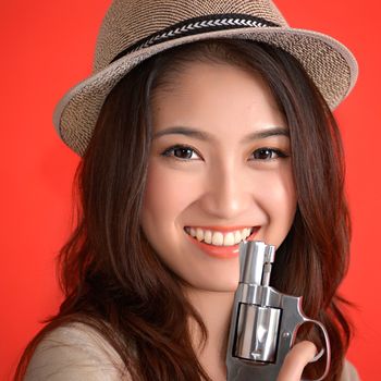 Young asian cute woman with handgun revolver