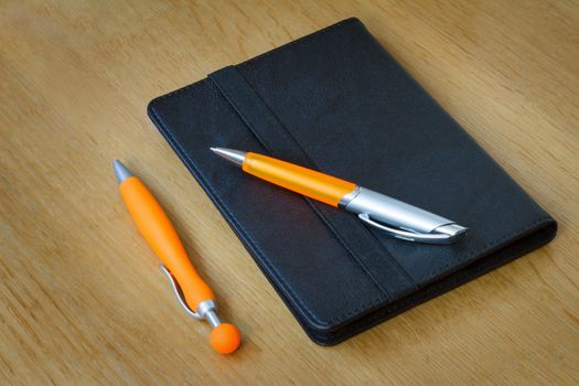 
Two handles of bright orange color for the letter and multi-colored paper clips for documents. Are located on a table