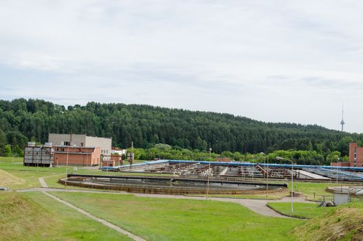 city sewage water treatment facility reservoir pools and equipment. Birds fly.