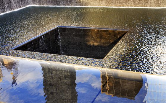 911 Memorial Pool Fountain Waterfall Reflections Abstract New York NY.  Pool is in the foundation of one of the Two World Trade Center Buildings.  Water falls into hole of the foundation.  