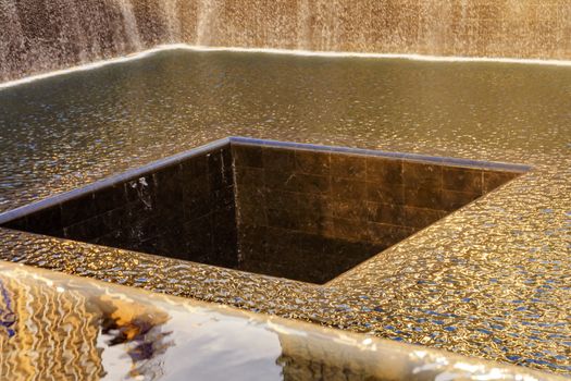 911 Memorial Pool Fountain Waterfall Reflections Abstract New York NY.  Pool is in the foundation of one of the Two World Trade Center Buildings.  Water falls into hole of the foundation.  