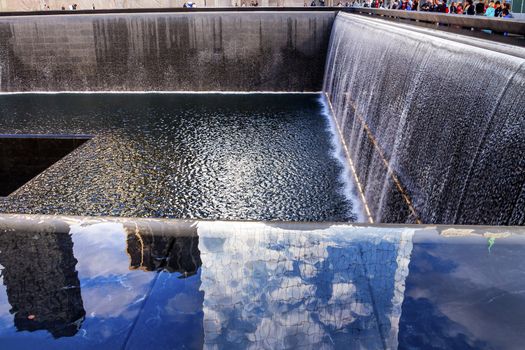 911 Memorial Pool Fountain Waterfall Reflections Abstract New York NY.  Pool is in the foundation of one of the Two World Trade Center Buildings.  Water falls into hole of the foundation.  