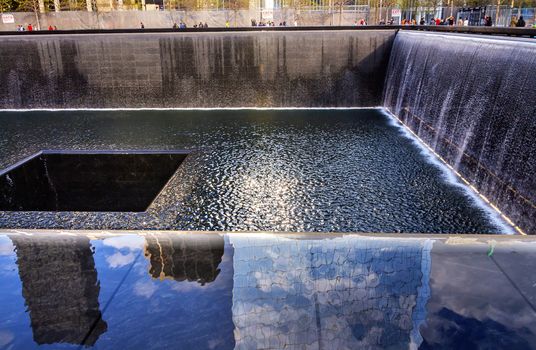 911 Memorial Pool Fountain Waterfall Reflections Abstract New York NY.  Pool is in the foundation of one of the Two World Trade Center Buildings.  Water falls into hole of the foundation.  