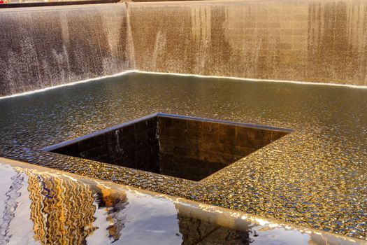 911 Memorial Pool Fountain Waterfall Reflections Abstract New York NY.  Pool is in the foundation of one of the Two World Trade Center Buildings.  Water falls into hole of the foundation.  