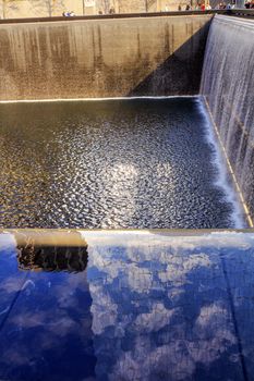 911 Memorial Pool Fountain Waterfall Reflections Abstract New York NY.  Pool is in the foundation of one of the Two World Trade Center Buildings.  Water falls into hole of the foundation.  