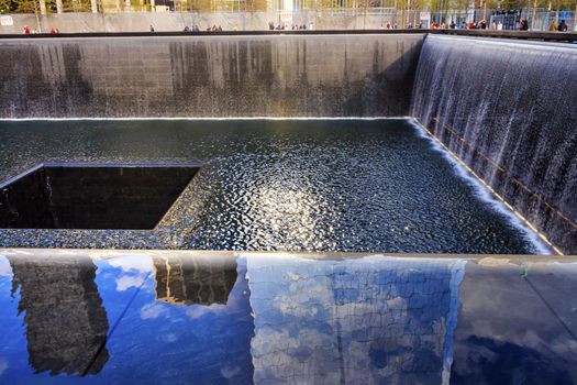 911 Memorial Pool Fountain Waterfall Reflections Abstract New York NY.  Pool is in the foundation of one of the Two World Trade Center Buildings.  Water falls into hole of the foundation.  