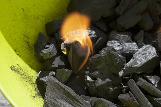 Burning carbon in a green barbeque, close up of fire