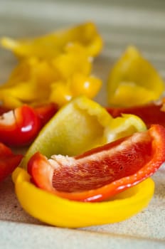 red and yellow peppers cut on wooden board